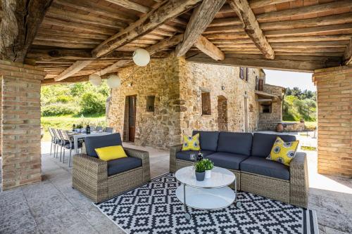 un patio al aire libre con sofás y una mesa en Villa Cantucci, en Volterra