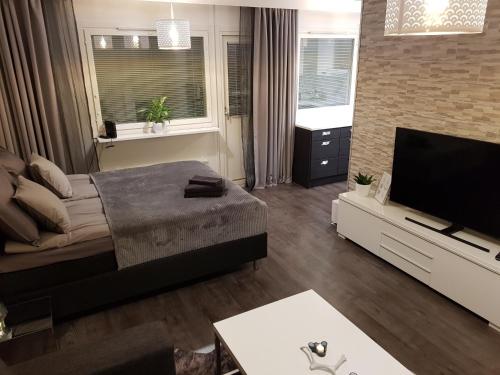 uma sala de estar com um sofá e uma televisão de ecrã plano em Vartiomaja - beautiful apartment near Arktikum em Rovaniemi