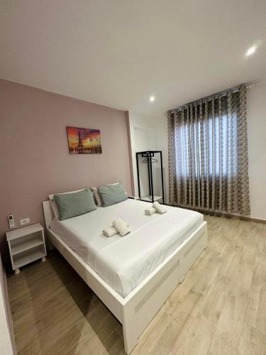 a large white bed in a bedroom with a window at Elite Inn in Vlorë