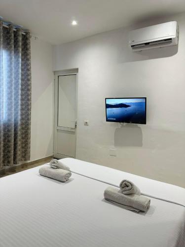 a bedroom with a bed and a flat screen tv at Elite Inn in Vlorë