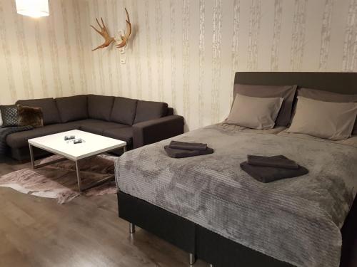 a bedroom with a large bed and a couch at Vartiomaja - beautiful apartment near Arktikum in Rovaniemi