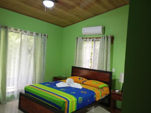 1 dormitorio con 1 cama con paredes verdes en Guapinol Lodge, 