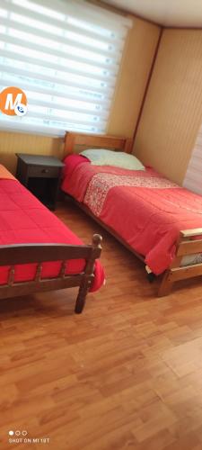 2 camas en una habitación con ventana en CASA PUERTO MONTT en Puerto Montt