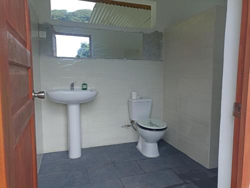 łazienka z umywalką i toaletą w obiekcie Camping TENUI w mieście Taputapuapea
