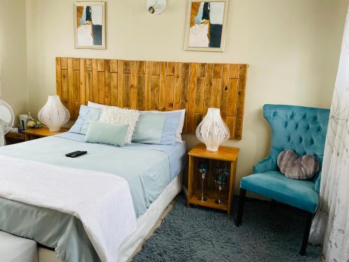 um quarto com uma cama e uma cadeira azul em Wampi guesthouse em Polokwane