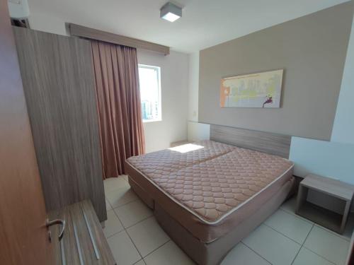 a small bedroom with a bed and a window at Riviera Park in Caldas Novas