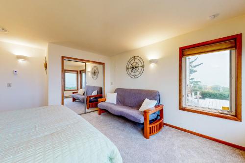 ein Schlafzimmer mit einem Bett und einem Stuhl und einem Fenster in der Unterkunft Pebble Beach Bliss in Crescent City