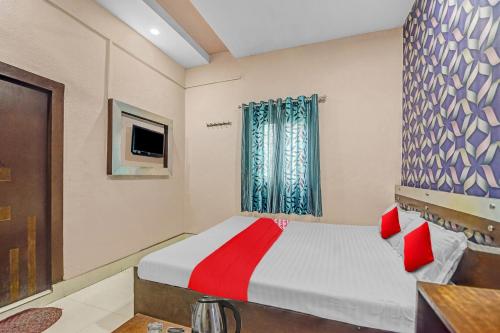 a bedroom with a bed with red pillows and a window at Flagship Hotel Royal in Rānchī