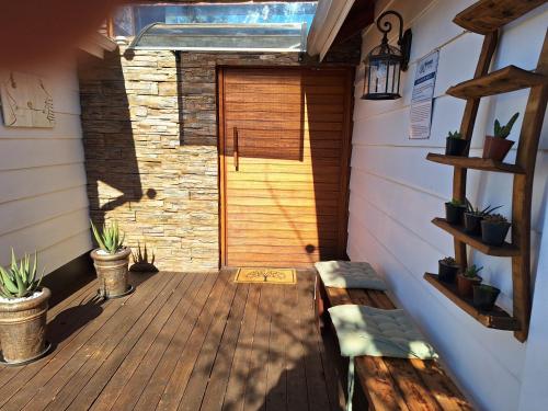 a porch with a wooden door and a bench at Tree Living in Krugersdorp