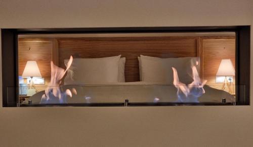a reflection of a person laying in a bed in a mirror at Likoria Hotel in Arachova