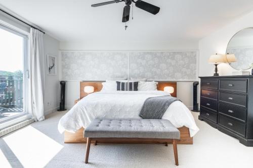 a white bedroom with a bed and a window at Tremblant Prestige - Les Eaux 227-3 in Mont-Tremblant