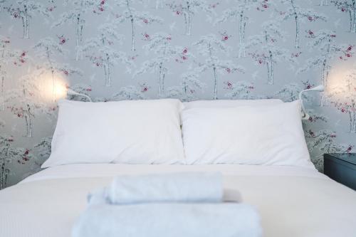 a white bed with white pillows in a bedroom at The Retreat near Salford Quays in Manchester
