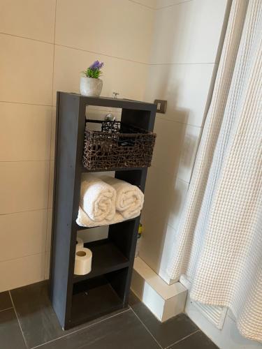 a black shelf with towels in a bathroom at Loft Cerro Alegre Valparaíso in Valparaíso