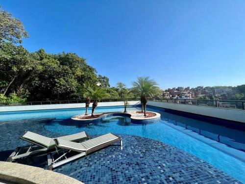 una piscina con tumbonas en un edificio en UNU Rio Vermelho: Piscina, vaga, wifi, academia, +, en Salvador