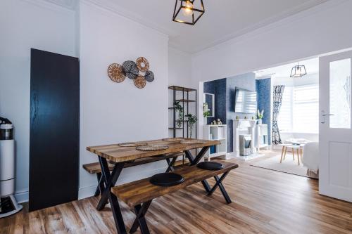 a kitchen and living room with a wooden table and bench at The Retreat near Salford Quays in Manchester