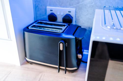 a blue toaster sitting on the floor next to a counter at The Retreat near Salford Quays in Manchester