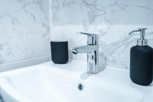 a bathroom sink with two soap dispensers on it at The Retreat near Salford Quays in Manchester