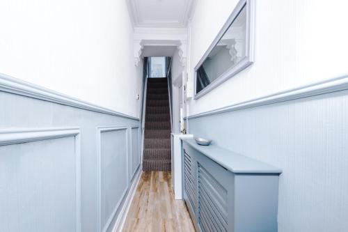 a hallway of a house with white walls and a staircase at The Retreat near Salford Quays in Manchester