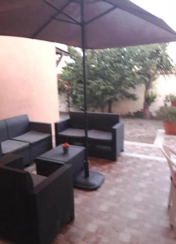 a patio with two couches and an umbrella at Sabrina Airport in Fiumicino