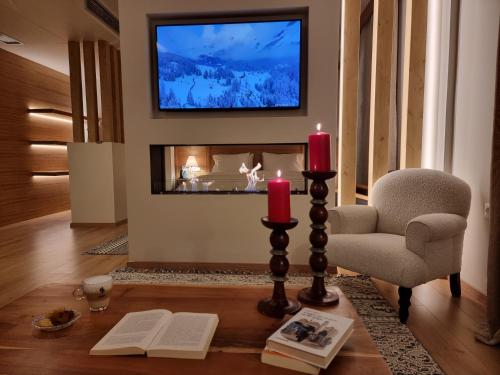 a living room with a fireplace with two candles and a chair at Likoria Hotel in Arachova