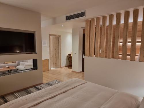 a bedroom with a bed and a flat screen tv at Likoria Hotel in Arachova