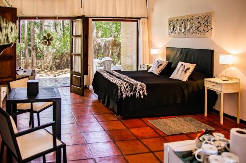 sypialnia z łóżkiem i drzwiami prowadzącymi na patio w obiekcie Posada La Casona w mieście Mar de las Pampas