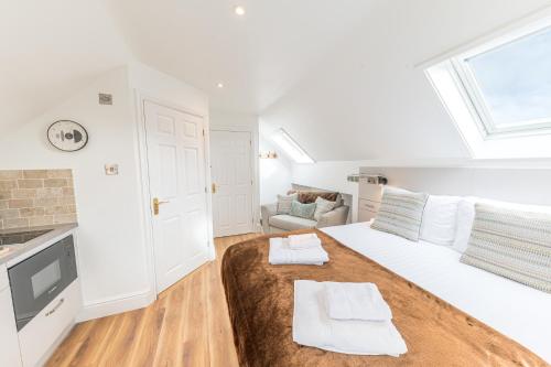 a white bedroom with a large bed and a window at Romantic getaway in this stylish studio with views and free parking in Burneside