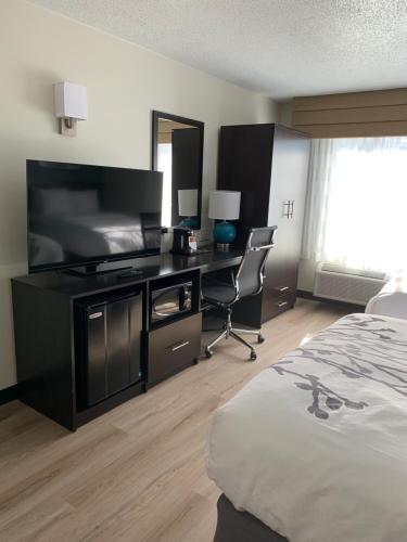 a hotel room with a bed and a desk and a television at Sleep Inn Staunton in Staunton