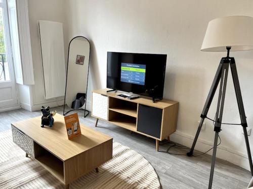 ein Wohnzimmer mit einem TV und einem Dreibettzimmer in der Unterkunft Studio Duquesne 1/2 pers in Nantes