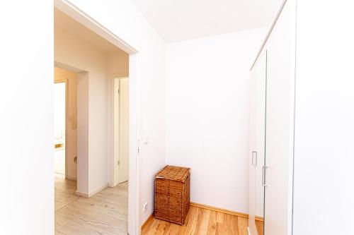un pasillo con una maleta de mimbre en una habitación en Grand Appartement nahe Müggelsee en Berlín