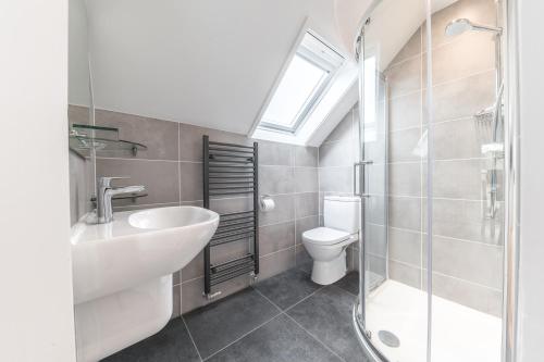 a bathroom with a sink and a toilet and a window at Romantic getaway in this stylish studio with views and free parking in Burneside
