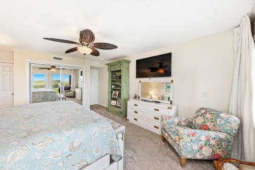 1 dormitorio con 1 cama con ventilador de techo y silla en Needle Rush Point Unit C11, en Pensacola