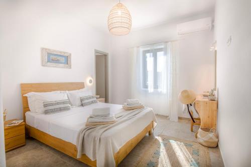 um quarto branco com uma cama grande num quarto em Empiria House - Agia Irini - Paros em Agia Irini Paros