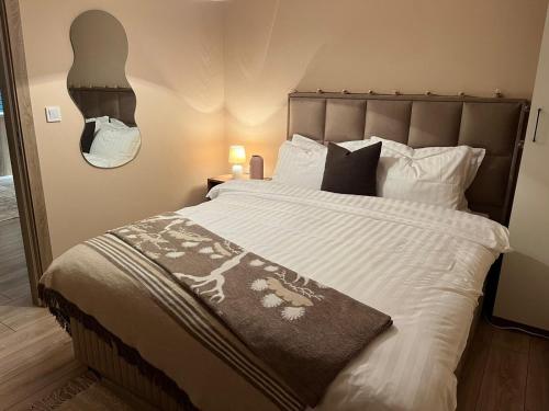 ein Schlafzimmer mit einem großen Bett mit weißer Bettwäsche und Kissen in der Unterkunft Adora's Apartment Mavrovo in Mavrovo-Nationalpark