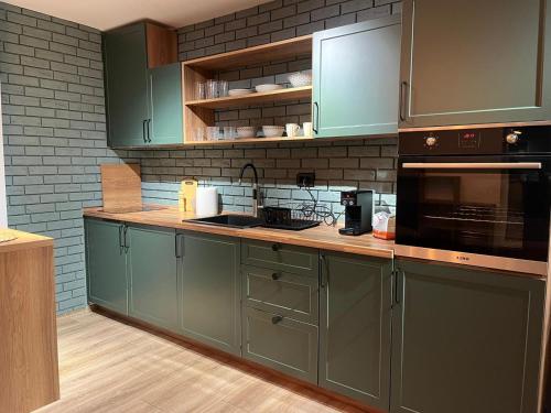 a kitchen with green cabinets and a stove top oven at Adora's Apartment Mavrovo in Mavrovo