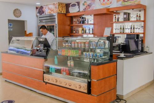 a man standing behind a counter in a store at Hotel Neiva Plaza in Neiva