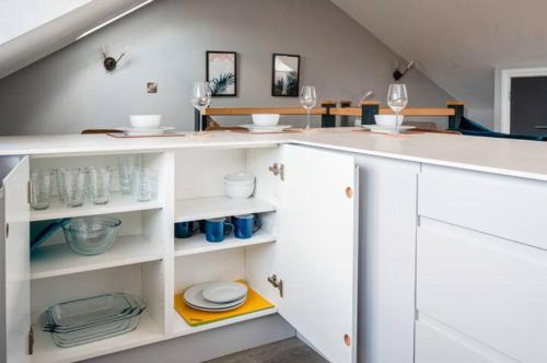 een keuken met witte kasten en wijnglazen bij Cosy 2-Bedroom Double En-Suite - Cathedral Views in Norwich