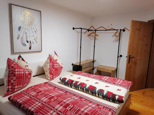 Una cama con almohadas rojas y blancas. en Apartment Martina en Telfs