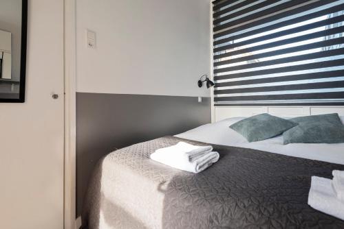 - une chambre avec un lit et des serviettes dans l'établissement De Schelp 18, Garden & Free Parking, à Zandvoort