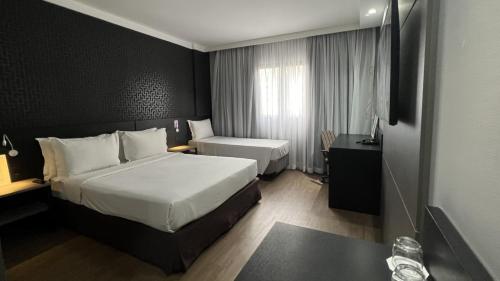 a hotel room with a large bed and a bathroom at Intercity São Paulo Berrini in Sao Paulo