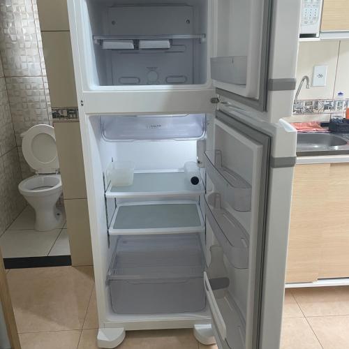 un frigorifero vuoto con la porta aperta in una cucina di Espaço LÍGIA homeoffice & suíte a Cubatão