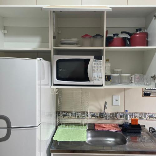 una cucina con frigorifero bianco e forno a microonde di Espaço LÍGIA homeoffice & suíte a Cubatão