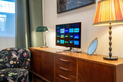 a hotel room with a desk with a television and a chair at Stylish Private Studio Close to City in Amsterdam