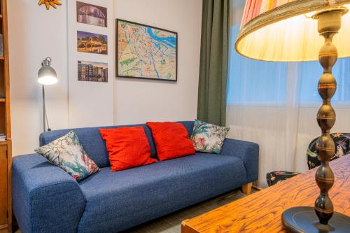 - un canapé bleu avec des oreillers rouges dans le salon dans l'établissement Fully fitted room - 15 min from central station, à Amsterdam
