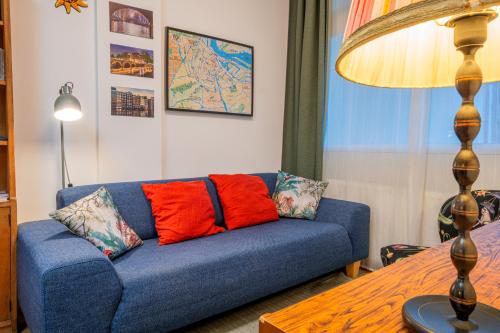 a blue couch with red pillows in a living room at Stylish Private Studio Close to City in Amsterdam