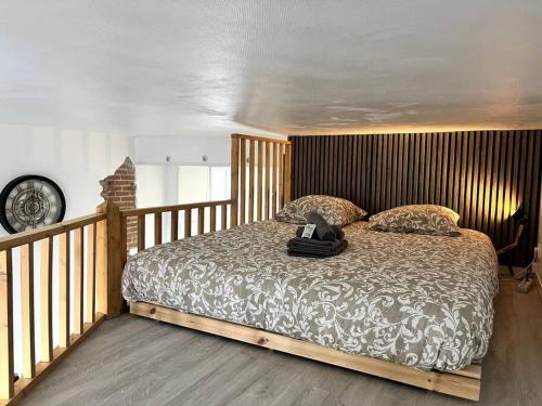 une chambre avec un grand lit avec une tête de lit en bois dans l'établissement Studio Petit Colombel 2pers Quartier St Felix, à Nantes