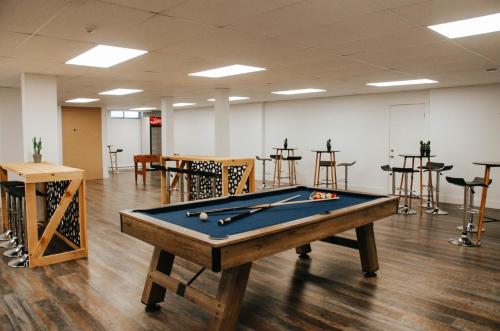 a pool table in a room with tables and stools at Suite 203 - Destination Mont-Orford in Magog-Orford