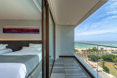 a bedroom with a view of the ocean at Lifestyle Laghetto Collection in Rio de Janeiro