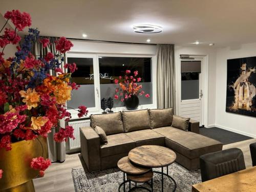 a living room with a couch and a table at Luxe woning Bubbles! Met airco en Parkeren op eigen grond in Castricum