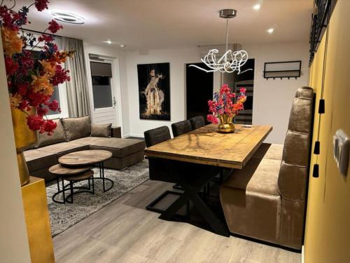 a living room with a table and a couch at Luxe woning Bubbles! Met airco en Parkeren op eigen grond in Castricum